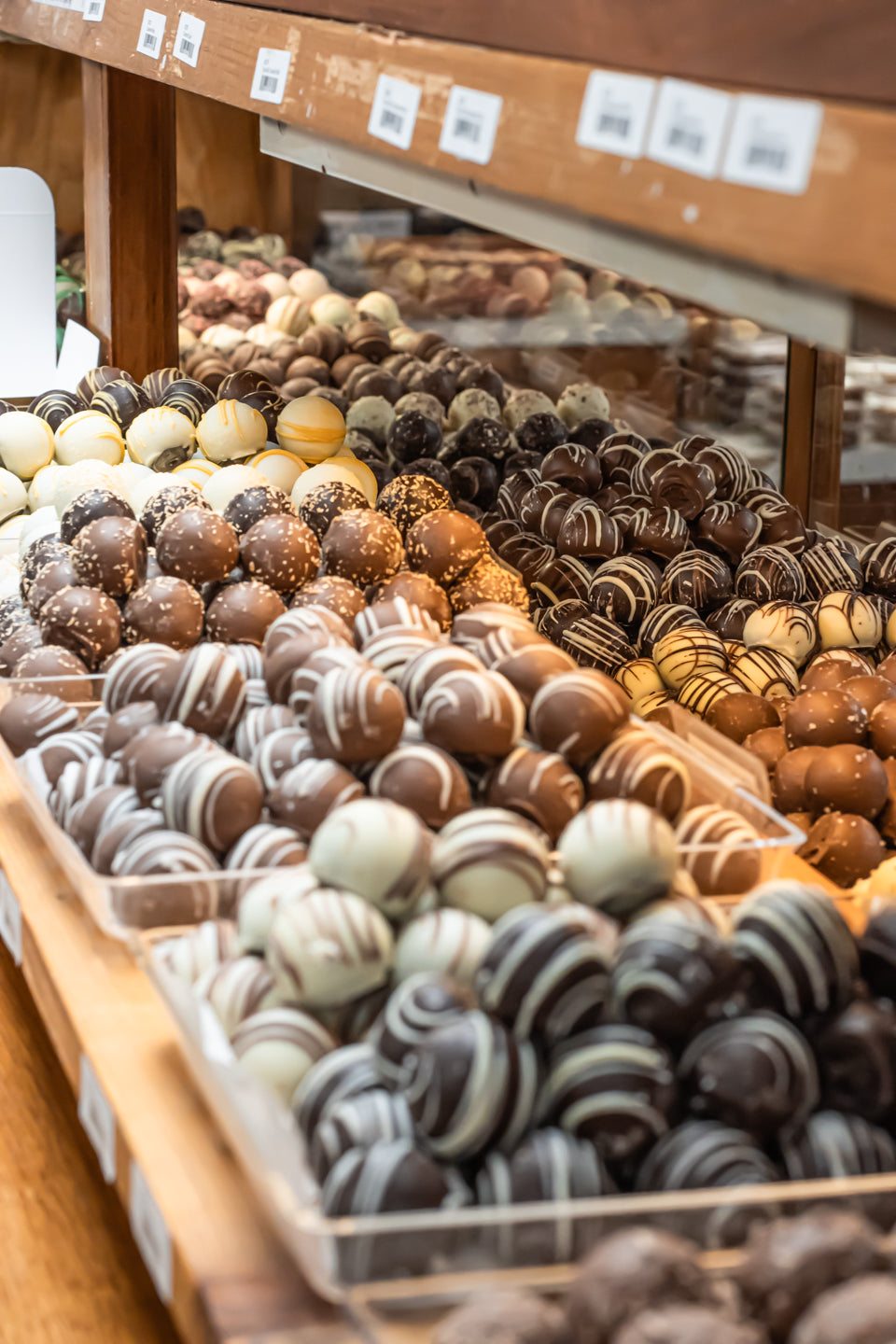 Assorted Truffles sitting in a case statcked up at hansel and gretel Candy Kicthen