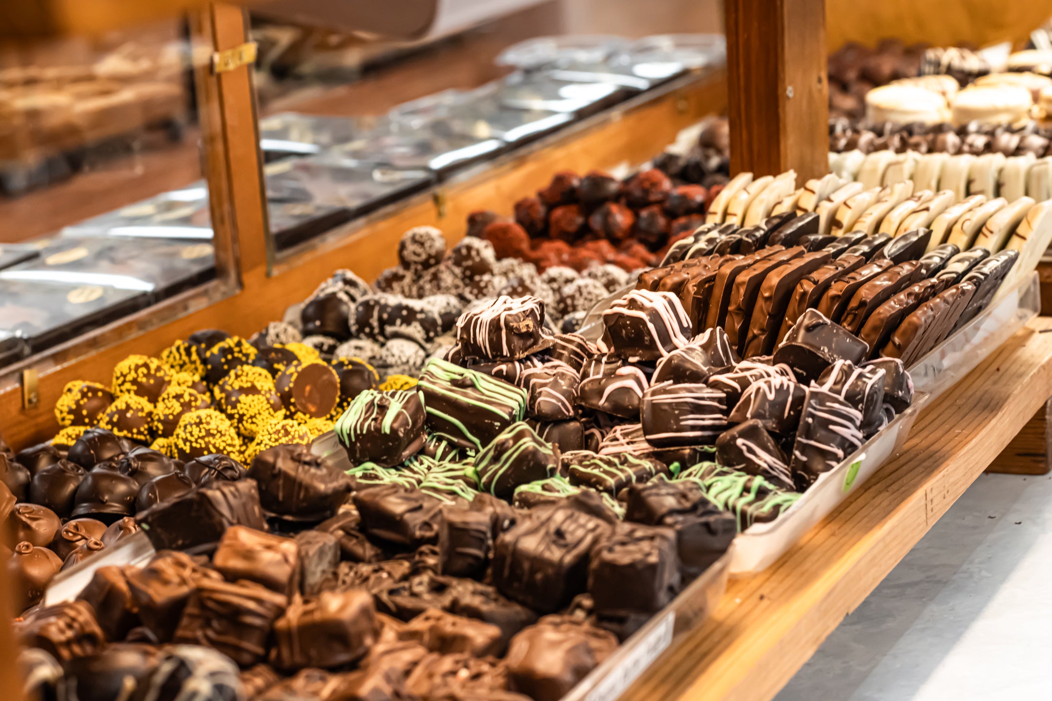 Assorted Chocolate Covered Caramels and Chocolate Covered Jellies sitting on trays in a case at Hansel and Gretel Candy Kitchen