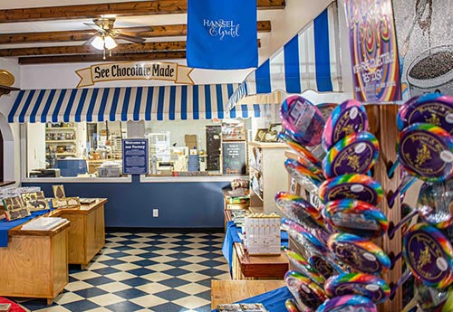 Inside of Outside of 8651 N Main St. Helen, GA Hansel and Gretel Candy Kitchen with a stand of lollipops fully stocked and a counter to order your sweets from